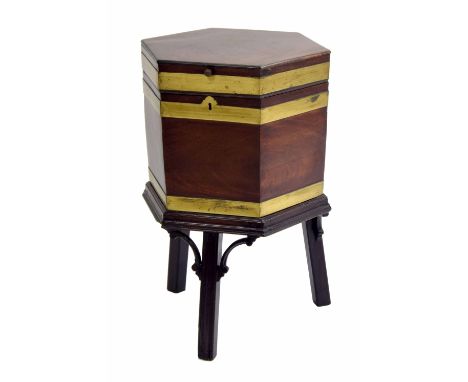 George III mahogany wine cooler on stand, of hexagonal form with brass banding, the hinged cover enclosing paper lined interi