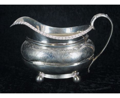 George III silver gilt cream jug, decorated with foliate and floral border, raised upon four ball feet, with leaf capped hand