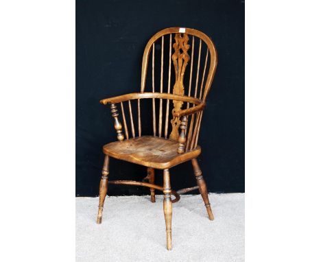 Yew wood Windsor chair, the comb back with pierced central splat, hoop arms, shaped seat, raised on splayed baluster turned l