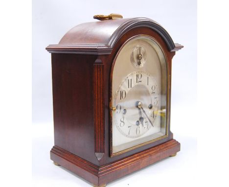 Mahogany bracket clock with moulded arched pediment, brushed metal face, applied chapter ring, Arabic numerals, plinth base a