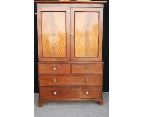 Late 19th century mahogany linen press, the projected moulded cornice over panelled doors enclosing slides, two short over tw