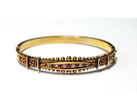 Victorian gold hinged bangle with graduated diamonds, rubies and beading, '15ct', c. 1880, cased, 9g.CONDITION REPORT: Intern