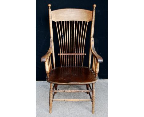 Oak comb back chair, the arched top rail over open baluster arms, shaped seat, raised on splayed turned legs united by stretc