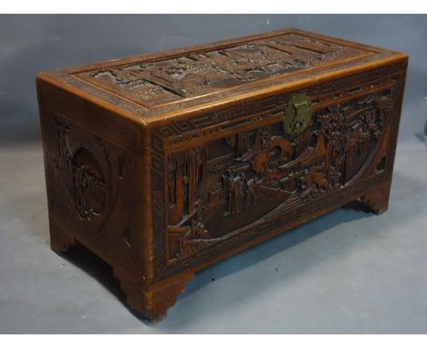 An early 20th century Chinese camphor wood trunk, profuseley carved, H.55 W.101 D.50cm 