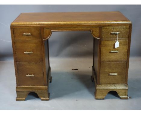 An Art Deco oak desk with six drawers, raised on bracket feet, H.71 W.98 D.44cm 