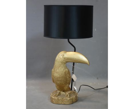 A gilt resin toucan table lamp, with black shade, H.72cm (total) 