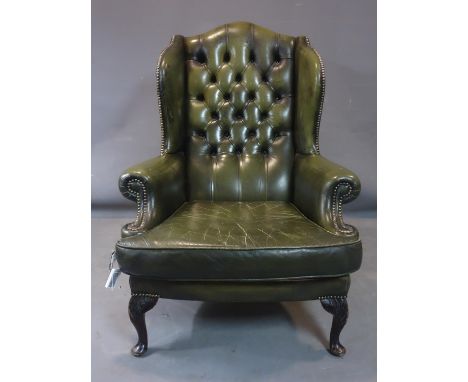 A 20th century button backed leather wingback armchair, on carved cabriole feet, H.109 W.85cm 
