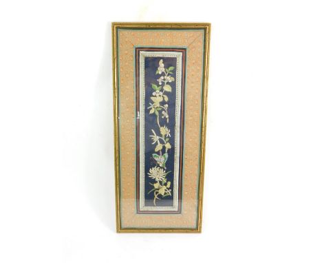 A Qing Dynasty silk sleeve panel, stitched with a butterfly and flowers, against a blue ground, framed, 60cm H, 24cm W.