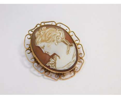 A 9ct gold and shell cameo brooch, bust portrait of a lady, in a 'C' scroll surround.