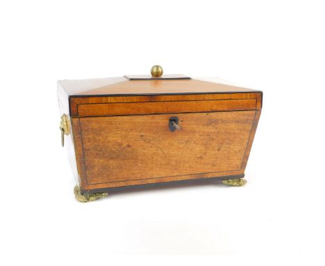 A Regency mahogany and ebony line inlaid tea caddy, of sarcophagus form, with twin lion's head and ring handles, the hinged l