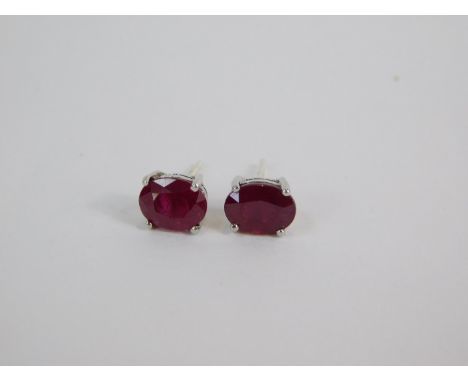 A pair of silver and oval cut ruby solitaire earrings, 3.54ct, with certificate.