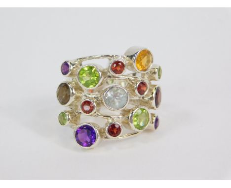 A silver and gemstone ring, in a kaleidoscope setting, with amethyst, rhodolite garnet, mozenbique garnet, Hunan and other pe