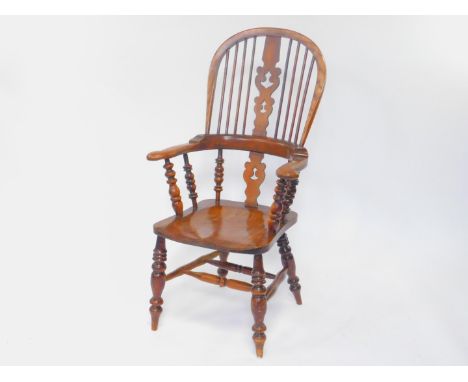 A Victorian ash and elm Windsor chair, with scrolling vase shaped splats, solid saddle seat raised on turned legs, united by 