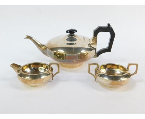 A George V silver three piece tea set, of compressed cylindrical form, comprising teapot, cream jug and sugar bowl, Birmingha