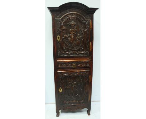 An 'antique carved oak cupboard,' with a door enclosing storage space and shelf, above a single short drawer and cupboard wit