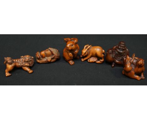 A collection of six Chinese carved boxwood netsuke, including three rabbits, an elder with a gourd, a dog of foe and a fish.
