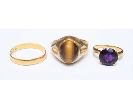 An 18ct gold and amethyst ring, 2.9 grams, together with a 22ct gold wedding band, 1.6 grams, and a 10ct gold and tigers eye 