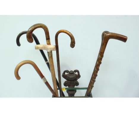 A small cast iron walking stick stand, together with a quantity of assorted walking sticks, one with horn handle.