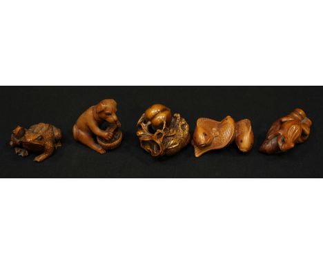 A collection of five Chinese carved boxwood netsuke, including three fish, a frog, a toad, dog with basket, and an apple.