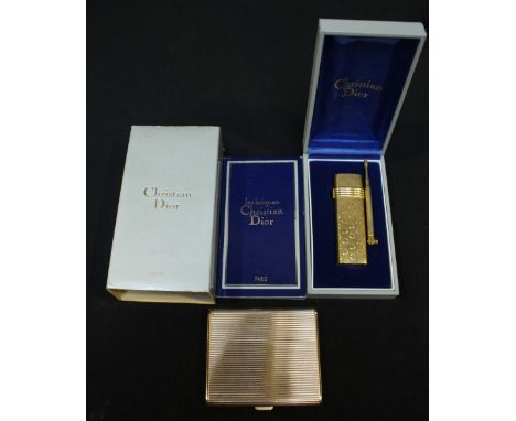 A Christian Dior gilt metal compact and a cigarette lighter, in original box with paperwork. (2)