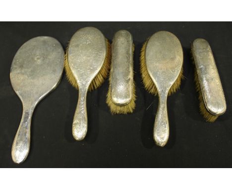 An Edwardian silver five-silver dressing table set, hallmarked London 1909, with engraved floral decoration, comprising two h