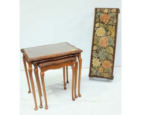 A nest of three walnut veneered occasional tables, together with a long low tapestry topped footstool. (2)