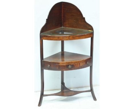 A Georgian mahogany corner washstand, with shaped splash-back, three circular wells, with shelf below and single drawer, supp