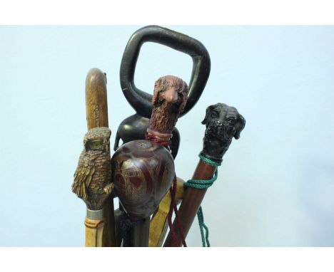 A Victorian cast iron walking stick stand, together with a quantity of assorted walking sticks, some with animal heads.