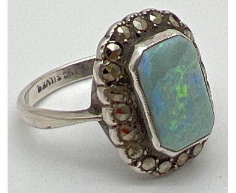 A vintage style silver dress ring set with an emerald cut opal, surrounded by marcasite stones. Inside of band stamped "Sterl