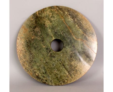 A GOOD LARGE CHINESE NEOLITHOIC JADE BI DISC, the predominantly green stone with russet veins and inclusions, 15.4in diameter