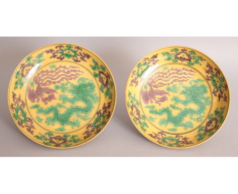 A PAIR OF CHINESE YELLOW GROUND PORCELAIN DISHES, each decorated in aubergine and green with a dragon and a phoenix within a 