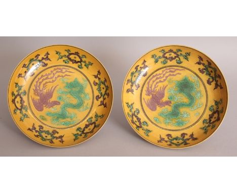 A PAIR OF CHINESE YELLOW GROUND PORCELAIN DISHES, each decorated in aubergine and green with a dragon and a phoenix within a 