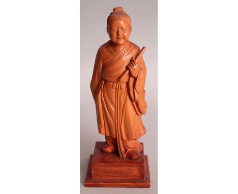 A GOOD QUALITY CHINESE COMMUNIST PERIOD CARVED WOOD FIGURE OF A STANDING SAGE, supported on a square plinth and bearing a scr