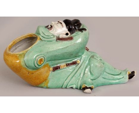 A GOOD CHINESE KANGXI PERIOD BISCUIT GLAZED FAMILLE VERTE PORCELAIN BRUSHWASHER, moulded in the form of a reclining sage clas