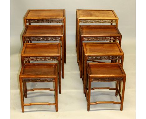 AN UNUSUAL PAIR OF EARLY 20TH CENTURY CHINESE FOUR-NEST CARVED HARDWOOD GRADUATED RECTANGULAR TABLES, each table with a pierc