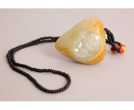 A CHINESE CELADON GREEN JADE PENDANT, with a beaded string attachment, the stone with russet inclusions and decorated in deep