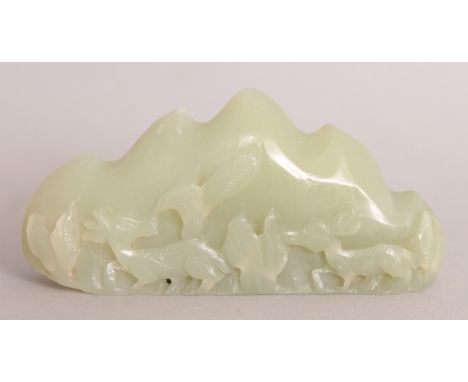 A CHINESE CELADON GREEN JADE BRUSH REST, decorated in relief with two deer in a rocky setting, 3.75in wide & 1.75in high.