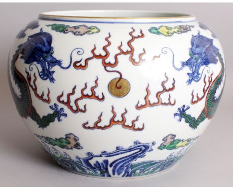 A LARGE CHINESE DOUCAI PORCELAIN DRAGON JARDINIERE, decorated with two dragons disputing a flaming pearl above stylised waves