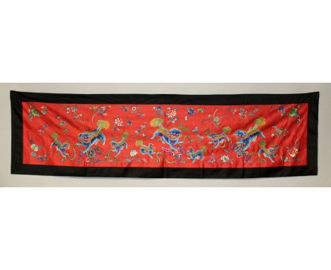 A GOOD QUALITY EARLY 20TH CENTURY CHINESE EMBROIDERED RED GROUND SILK WALL HANGING, decorated in vivid colours in satin stitc