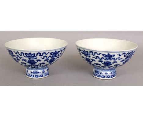 A PAIR OF CHINESE BLUE & WHITE PORCELAIN STEM BOWLS, each decorated to the sides with formal scrolling lotus beneath the Eigh