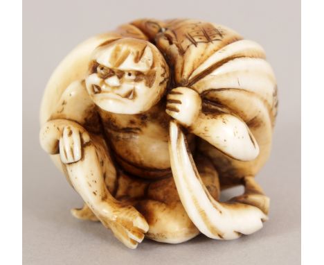 A JAPANESE MEIJI PERIOD STAINED IVORY NETSUKE OF A SQUATTING ONI, bearing behind him a large sack, 1in high.