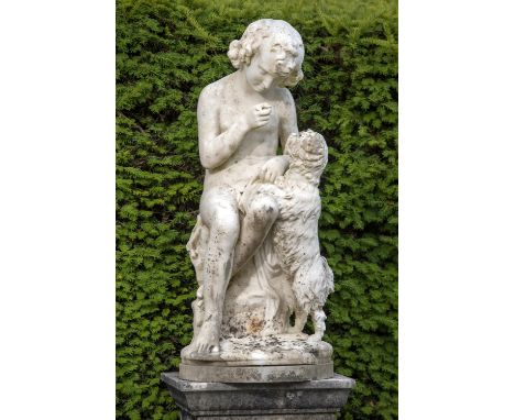 Garden statues: A white marble group of a conveniently draped boy seated on a rocky outcrop, a dog jumping at his side, the c