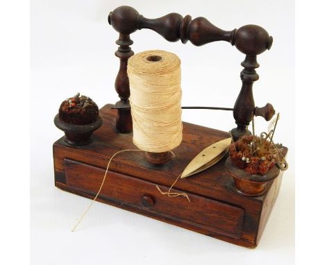 Nineteenth century rosewood bobbin stand with fitted drawer and a bone shuttle, 14cm high 