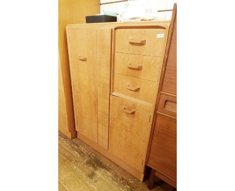 20th century G-Plan compactum in light oak, left hand wardrobe door and to the right three drawers above cupboard door, raise
