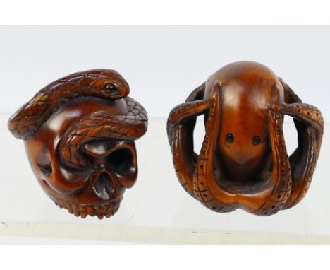 Two Japanese carved wood netsuke, the first in the form of an octopus, the other a skull and snake. [W]Condition Report: Gene