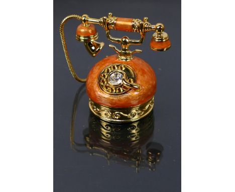 Estee Lauder - A boxed enamel Estee Lauder solid perfume compact in the form of a telephone. Compact has solid perfume on the