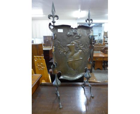 A 19th Century copper fire screen with heraldic embossed pattern 