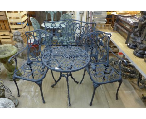 A cast alloy circular garden table, bench and pair of matching armchairs 