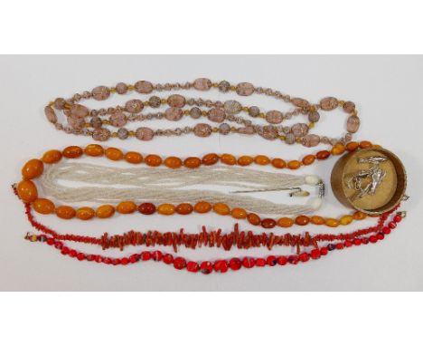 A string of butterscotch amber beads, 69.5cm, the largest bead 1.4cm x 1.9cm, 36.4g gross, a coral branch 38cm longfringe nec