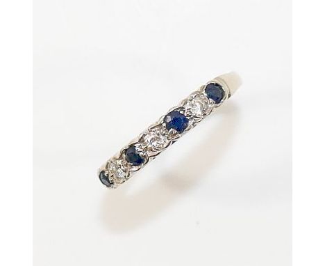 An 18ct white gold sapphire and diamond half eternity ring, the four mixed cut sapphires interspersed with three round brilli